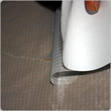 Carefully roll the patch onto the tear whilst holding the material either side taught.